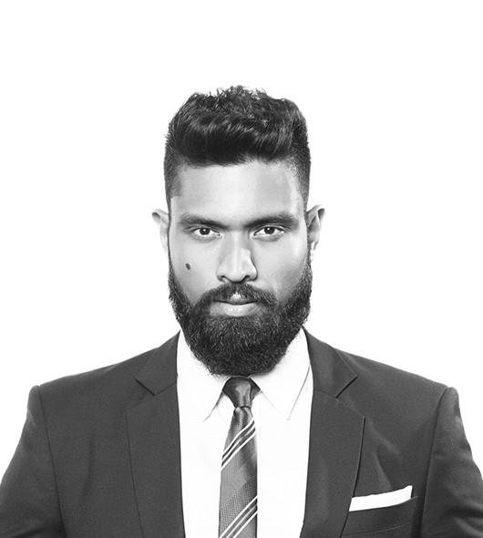 Black and white portrait of Arantha Sirimanne, co-founder of GrowthChord, in a dark suit and striped tie, on a white background